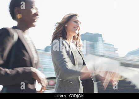 Smiling corporate businesswomen walking outdoors Stock Photo