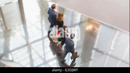 Corporate business people walking in a row in modern office lobby Stock Photo