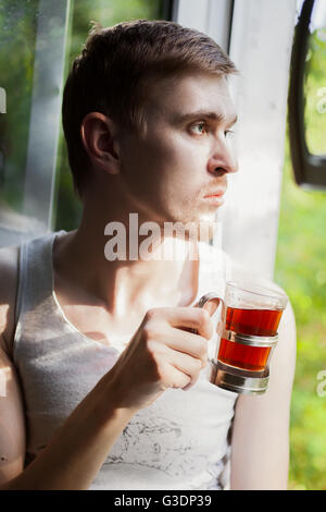 Portrait of young man drinking tea near the window Stock Photo