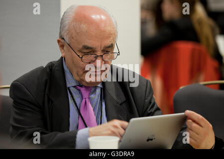 Middle aged man using an iPod in office - USA Stock Photo