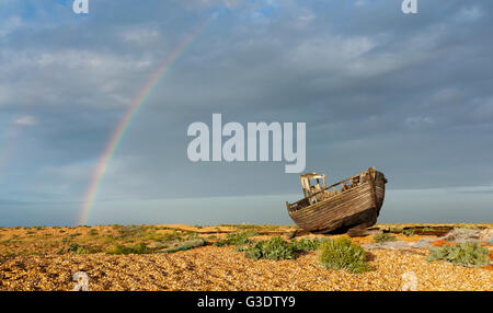 An old fishing boat on the Dungeness coast with a rainbow in the background. Stock Photo