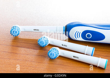 Electronic toothbrush with toothbrush heads on a table. Stock Photo