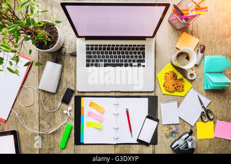 Aerial view of laptop with other modern electonic devices on desk. Modern hipster office interior Stock Photo