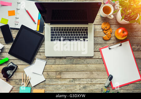 Aerial view of laptop with other modern electonic devices on desk. Modern hipster office interior Stock Photo