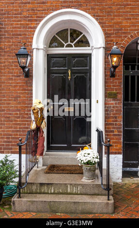 A red brick town house with an elegant arched entrance with a black painted front door in the Georgetown area of  Washington DC , USA Stock Photo
