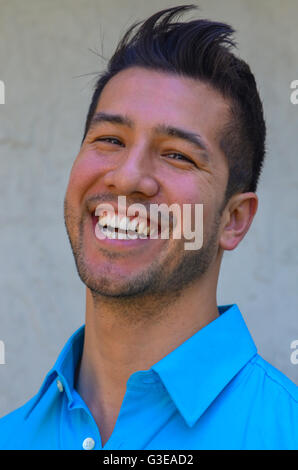portrait of a handsome young Hispanic man smiling and laughing and looking very happy Stock Photo