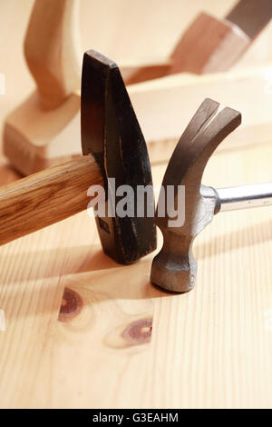 Two hammers near plane on wooden workbench Stock Photo