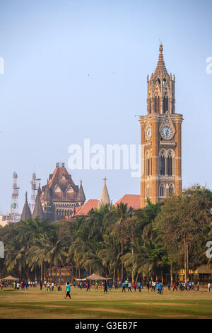 Rajabai clock tower in gothic style and green cricket field in Mumbai, Maharashtra, India Stock Photo