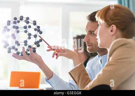 Innovative business people examining model in meeting Stock Photo