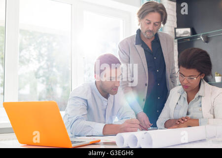 Architects discussing blueprints in office meeting Stock Photo