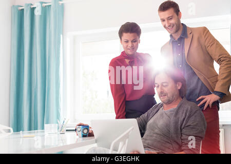 Business people sharing laptop in office meeting Stock Photo