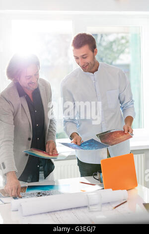 Creative businessmen reviewing photography proofs in office Stock Photo