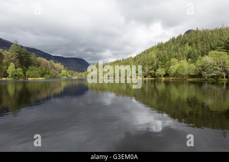 Village of Glencoe, Scotland. Glencoe Lochan, with the Pap of Glencoe summit just visible above the treeline in the background. Stock Photo