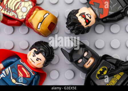 Four Lego Super Heroes - Iron Man, Batman, Superman, Nightwing - minifigures on Lego gray baseplate background.