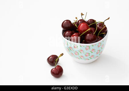 Fresh cherries in a bowl on a white background. Stock Photo