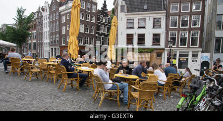 tourists sitting in a cafe on Singel bridge over the canal in Amsterdam Stock Photo