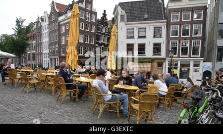 tourists sitting in a cafe on Singel bridge over the canal in Amsterdam Stock Photo