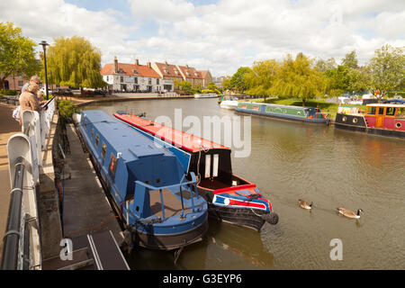 People looking at boats on the Great Ouse river on a spring day in Ely, Cambridgeshire East Anglia UK Stock Photo