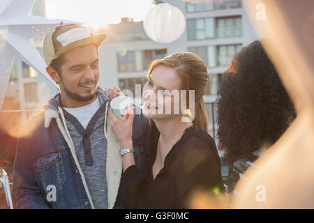 Young couple drinking and enjoying rooftop party