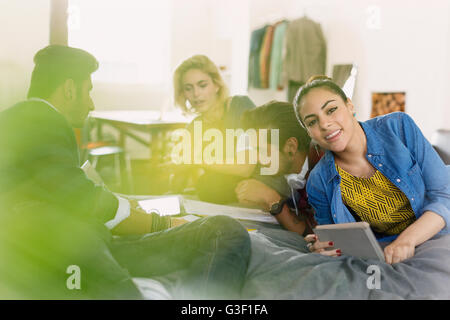 Portrait smiling college student studying with friends on bed Stock Photo