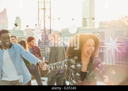Playful young couple at rooftop party Stock Photo