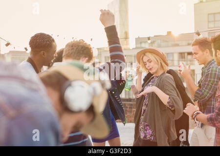 Young adult friends dancing at rooftop party Stock Photo