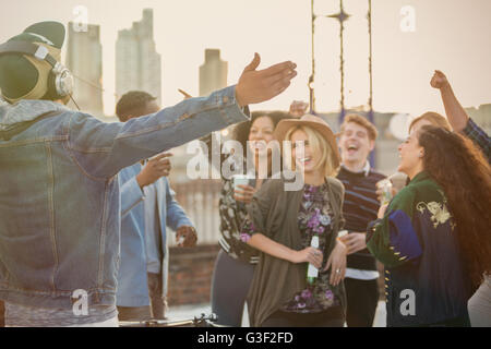 Crowd cheering for DJ at rooftop party Stock Photo