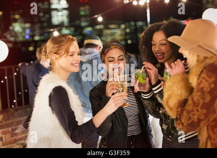 Young women drinking and enjoying rooftop party Stock Photo