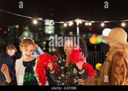 Young women dancing at rooftop party Stock Photo