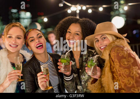 Portrait enthusiastic young women drinking cocktails at party Stock Photo