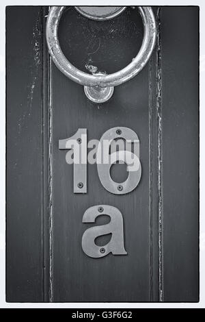 Light blue English period wooden front door with ornate iron door knocker. House number position under door knocker. Soft natura Stock Photo