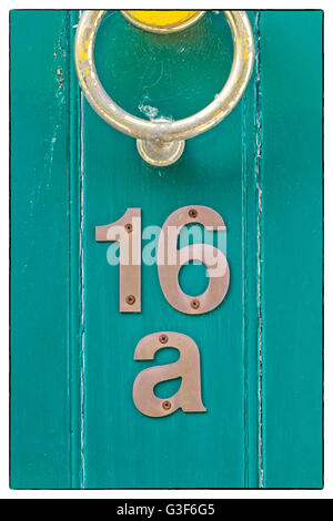 Light blue English period wooden front door with ornate iron door knocker. House number position under door knocker. Soft natura Stock Photo