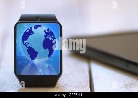 Smart watch on a white wooden table connected to a smart phone. Global communication symbol. Empty copy space for Editor's text. Stock Photo