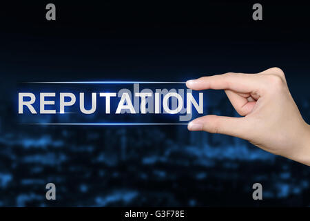 hand pushing reputation button on blurred blue background Stock Photo
