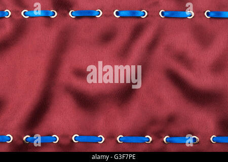Fashionable beautiful background, blue satin ribbon inserted in red satin fabric, with space for your creativity Stock Photo