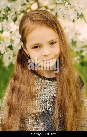 Portrait of little cute beautiful girl in garden Stock Photo