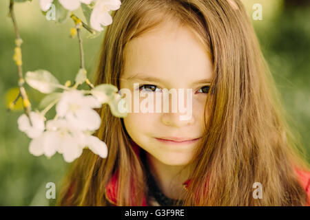 Portrait of little cute beautiful girl in garden Stock Photo