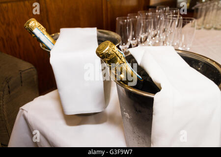 Row of champagne flutes and two bottles in ice buckets ready for pouring toast. Stock Photo