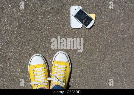 Disassembled smartphone on the ground in front of person. First person point of view Stock Photo