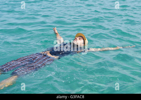 Dressed up man floating on the water. Summer relaxation Stock Photo