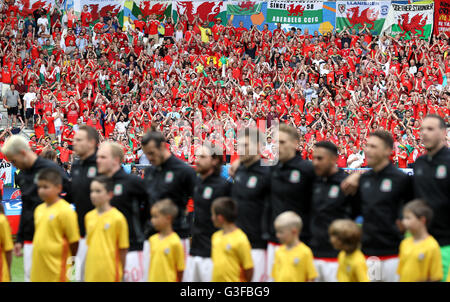 Wales fans show their support in the stands as the national anthem plays during the UEFA Euro 2016, Group B match at the Stade de Bordeaux, Bordeaux. PRESS ASSOCIATION Photo. Picture date: Saturday June 11, 2016. See PA story SOCCER Wales. Photo credit should read: Martin Rickett/PA Wire. RESTRICTIONS: Use subject to restrictions. Editorial use only. Book and magazine sales permitted providing not solely devoted to any one team/player/match. No commercial use. Call +44 (0)1158 447447 for further information. Stock Photo