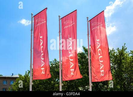 Official dealership flags of Jaguar against the blue sky background. Stock Photo