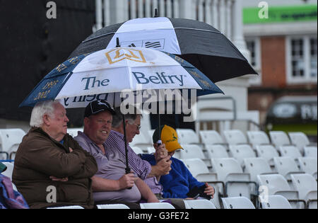 Trent Bridge, Nottingham, UK. 10th June, 2016. Natwest T20 Blast Cricket. Notts Outlaws versus Derbyshire Falcons. Fans shelters under umbrellas as rain delays the start at Trent Bridge. © Action Plus Sports/Alamy Live News Stock Photo