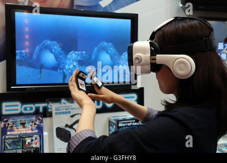 Tokyo, Japan. 10th June, 2016. An employee of Japanese toy maker MegaHouse demonstrates virtual reality toy 'BotsNew' using a smart phone inside the unit and handy controlers at the annual Tokyo Toy Show in Tokyo on Friday, June 10, 2016. Some 160,000 people are expecting to visit the four-day toy trade show. © Yoshio Tsunoda/AFLO/Alamy Live News Stock Photo