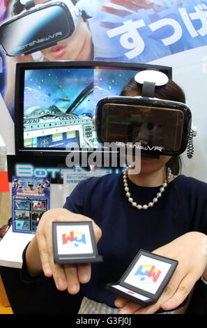 Tokyo, Japan. 10th June, 2016. An employee of Japanese toy maker MegaHouse demonstrates virtual reality toy 'BotsNew' using a smart phone inside the unit and handy controlers at the annual Tokyo Toy Show in Tokyo on Friday, June 10, 2016. Some 160,000 people are expecting to visit the four-day toy trade show. © Yoshio Tsunoda/AFLO/Alamy Live News Stock Photo