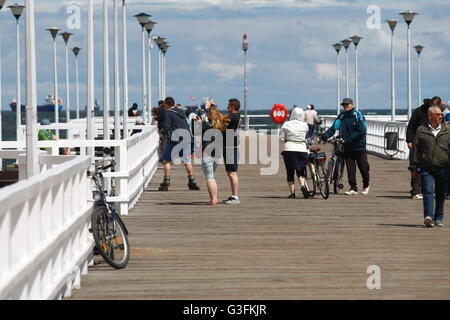 Gdansk, Poland 11th, June 2016 Sunny but cold Saturday in Gdansk, After few weeks of very warm weather, today temperature dropped to 14 Celsius degrees. Cooling sensation is intensified by a strong northern wind. People walking on the Brzezno pier are seen. Credit:  Michal Fludra/Alamy Live News Stock Photo