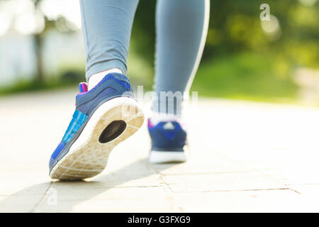 Running shoes - closeup of female sport fitness runner getting ready for jogging outdoors in summer Stock Photo