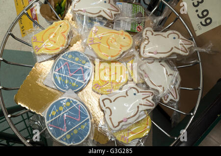 Wrapped Easter egg, chick and rabbit cookies in grocery store checkout line basket. St Paul Minnesota MN USA Stock Photo