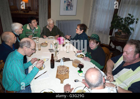 Group of adults sitting around a table enjoying a delicious St Patrick's Day meal & good conversation. St Paul Minnesota MN USA Stock Photo