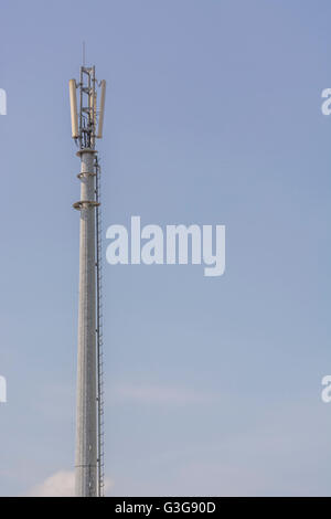 Mobile / Cellular telephone network mast set against blue skies. Concept of mobile network, communications, mobile phones. Stock Photo